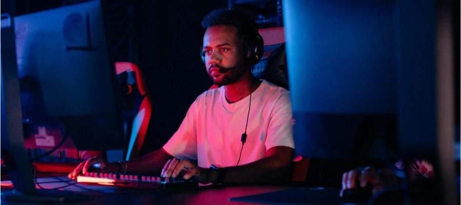 A person sat at a desk with 2 monitors in front of them streaming.