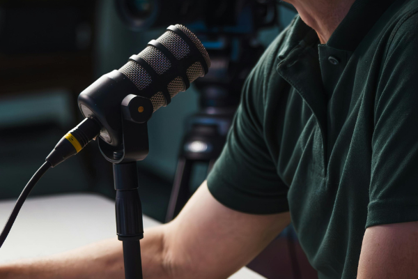 A person in a green top talking into a microphone