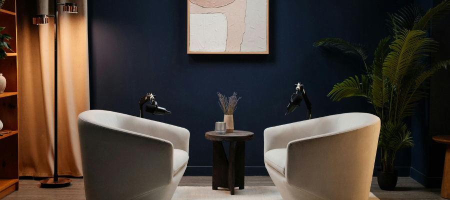 2 white chairs set up facing each other with a small table between them.